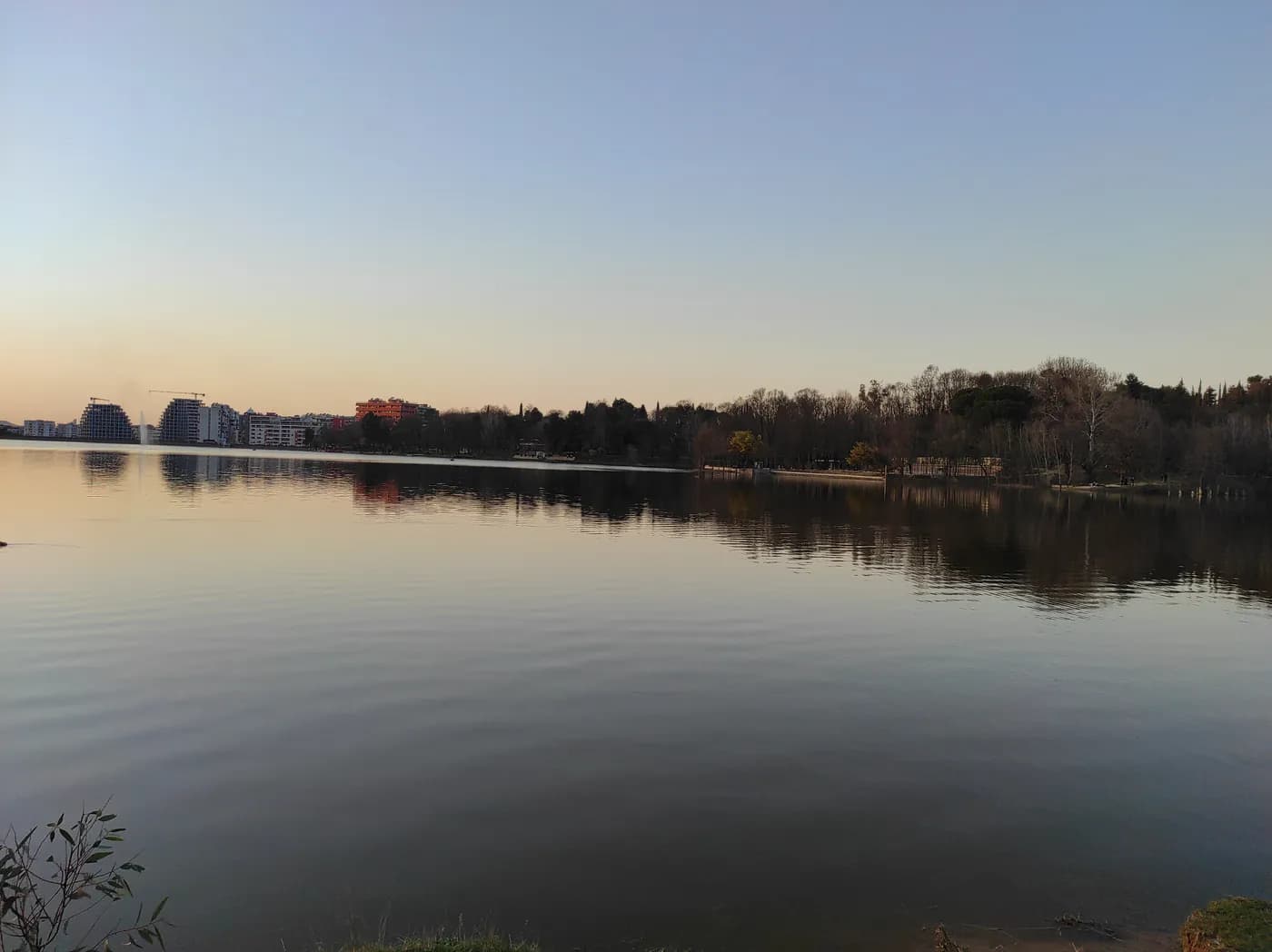 The tree-lined shore of Tirana's Artificial Lake in the Grand Park